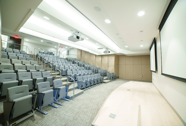 Stadium seating and presentation screens in the lecture hall